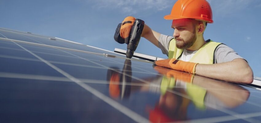 Installateur die zonnepanelen bevestigd op een dak